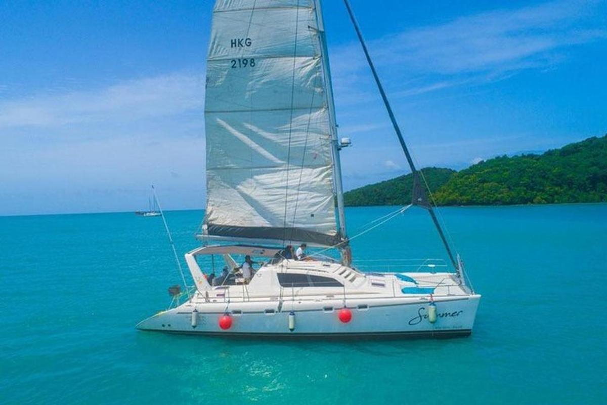 a white sail boat in the ocean on the water