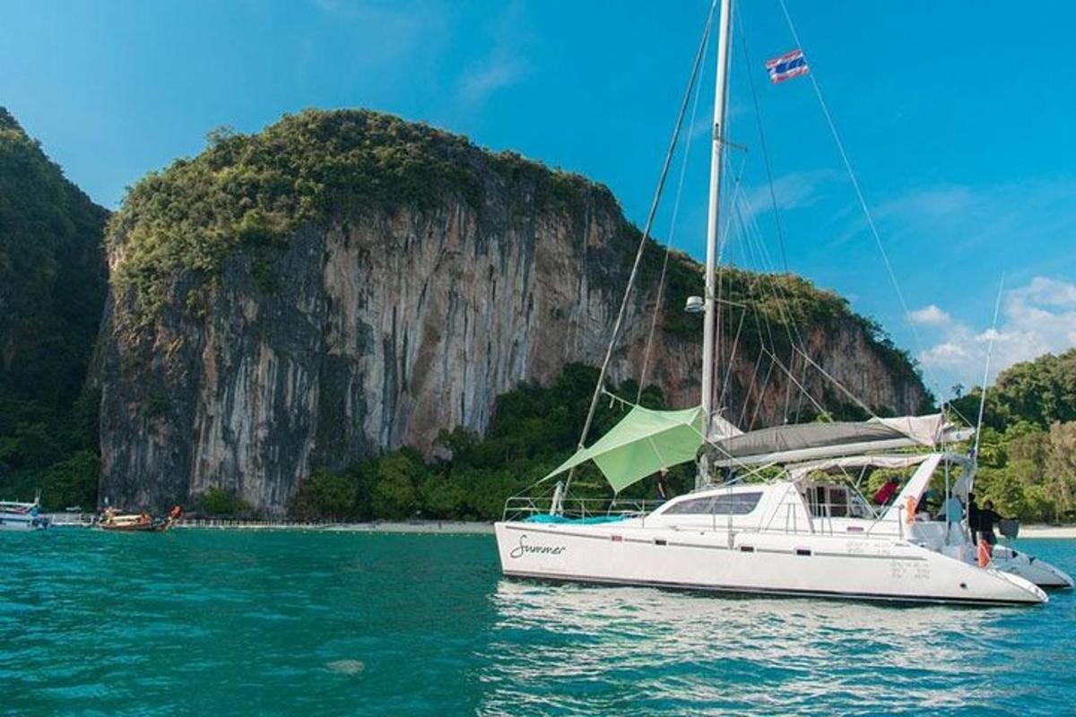 perahu layar putih di air dengan gunung