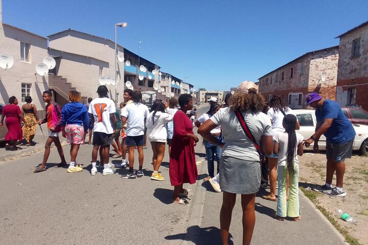 un gruppo di persone in piedi sul ciglio di una strada