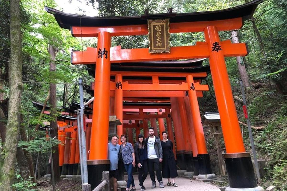 Skupina lidí stojících před bránou torii