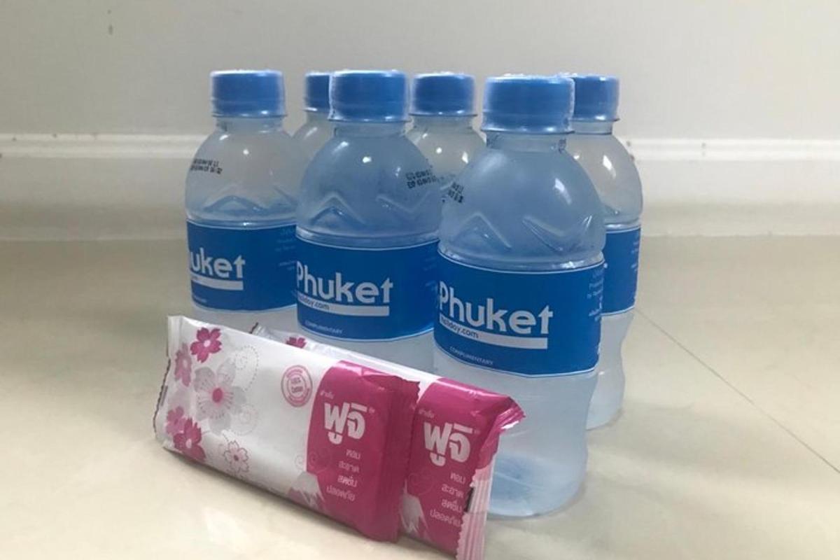 vier Flaschen Wasser in einem Kühlschrank neben einer Packung Milch