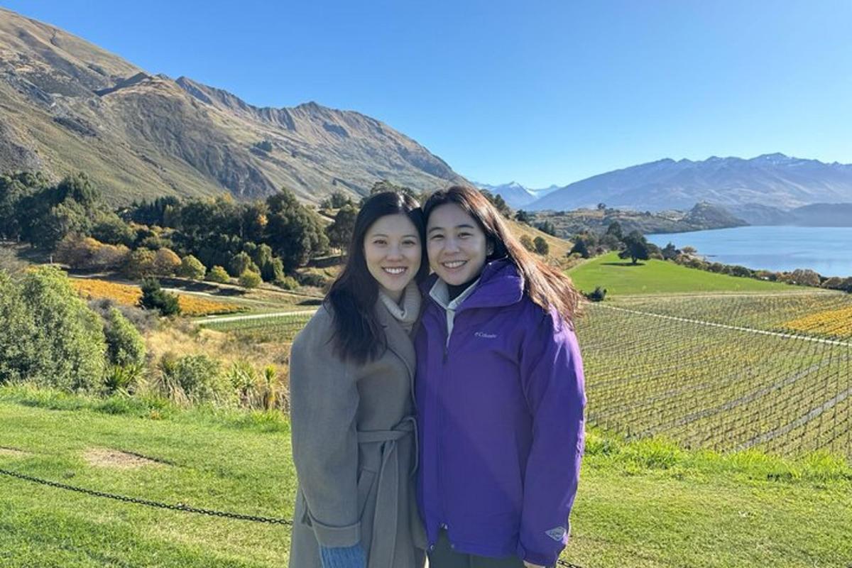 two women standing next to each other on a hill
