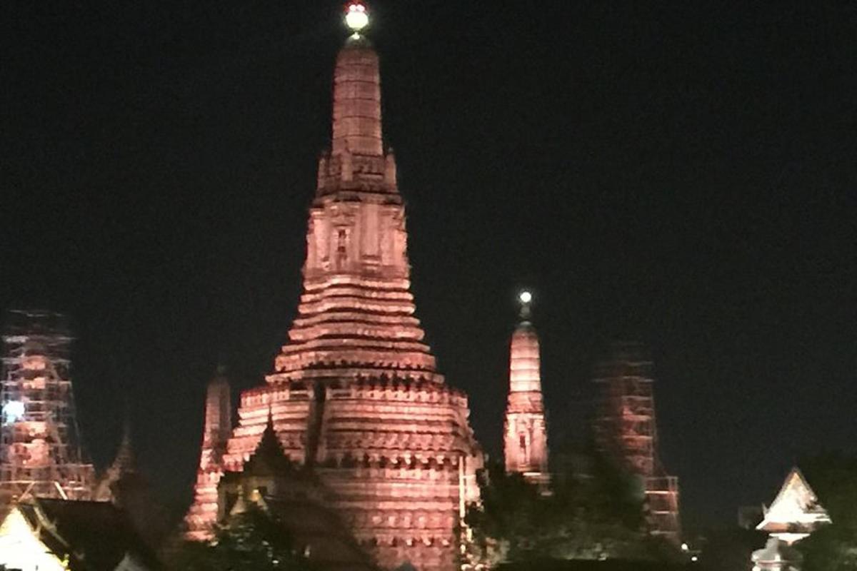 sebuah bangunan tinggi dengan menara yang menyala pada waktu malam
