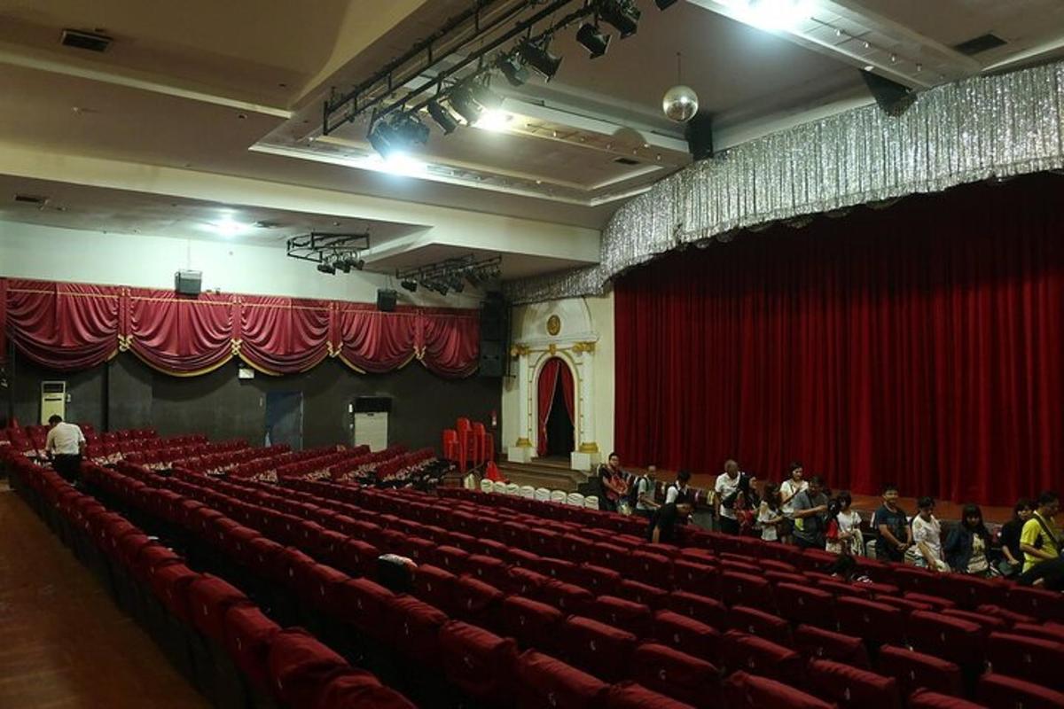 un auditorium con sedili rossi e persone in un teatro