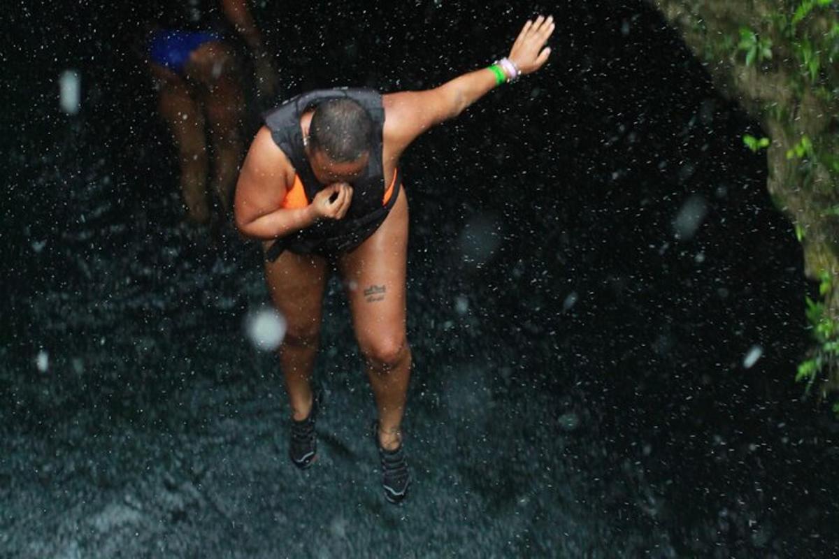 un uomo in costume da bagno in piedi sotto la pioggia