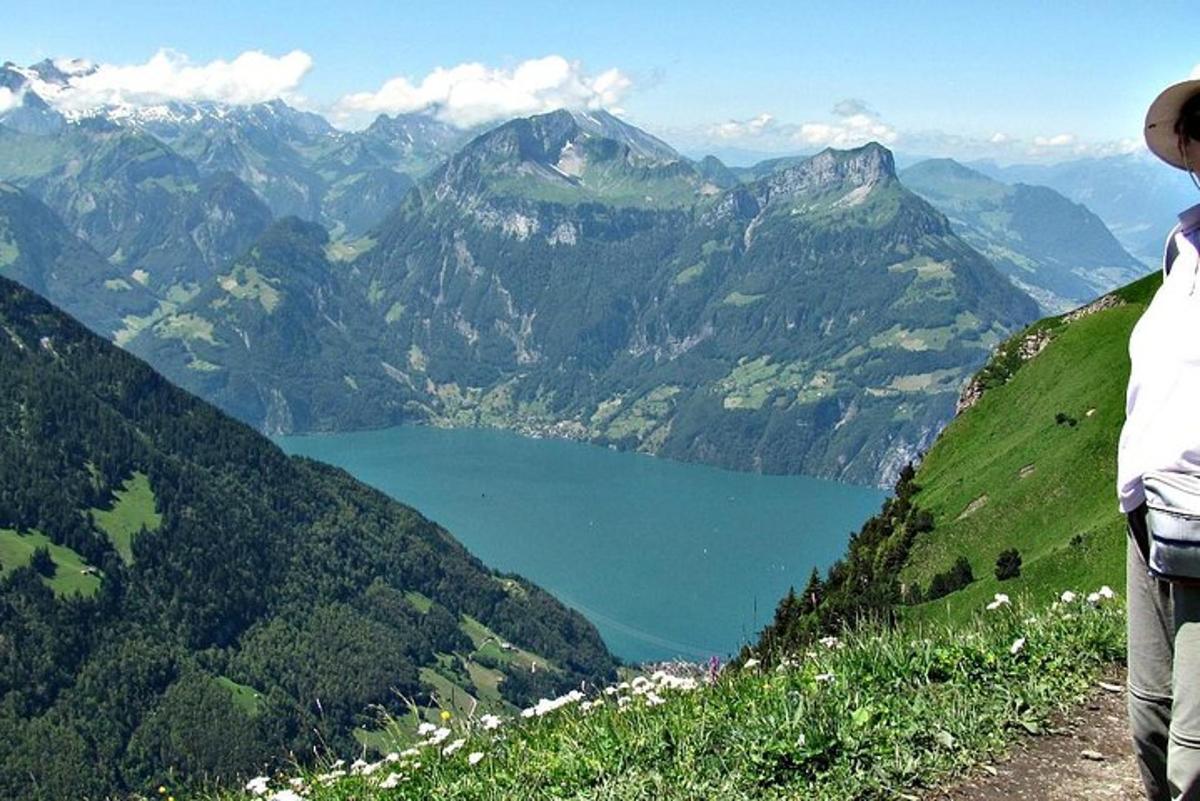 una persona in piedi sulla cima di una montagna che domina un lago