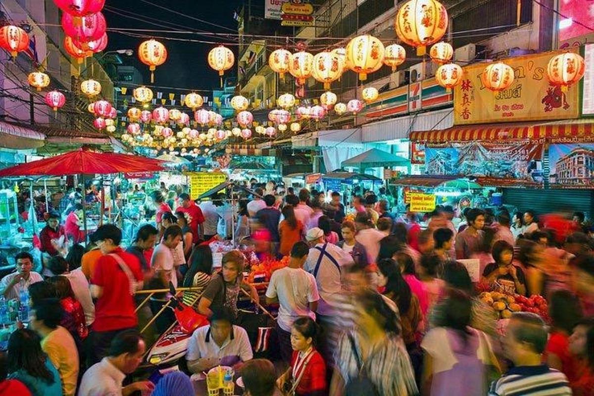 Una multitud de personas caminando por un mercado lleno de gente