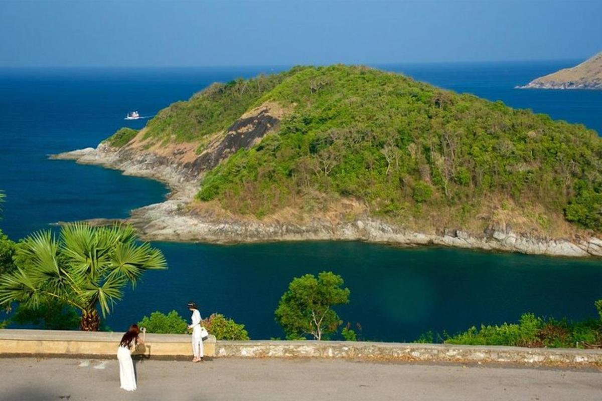 two people standing on a wall looking at an island