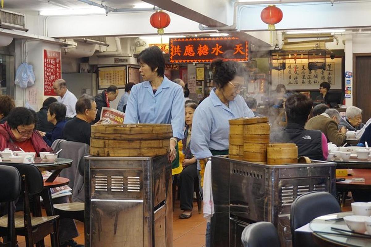 dues persones dempeus en un restaurant amb gent menjant