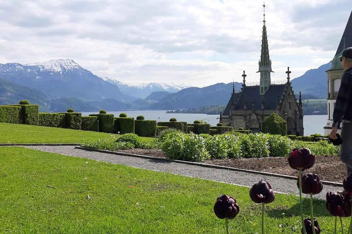a garden with a church and a lake and mountains