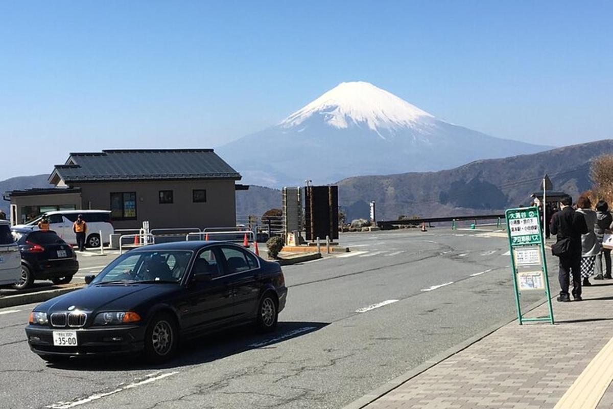 a black car parked in front of a snow covered mountain