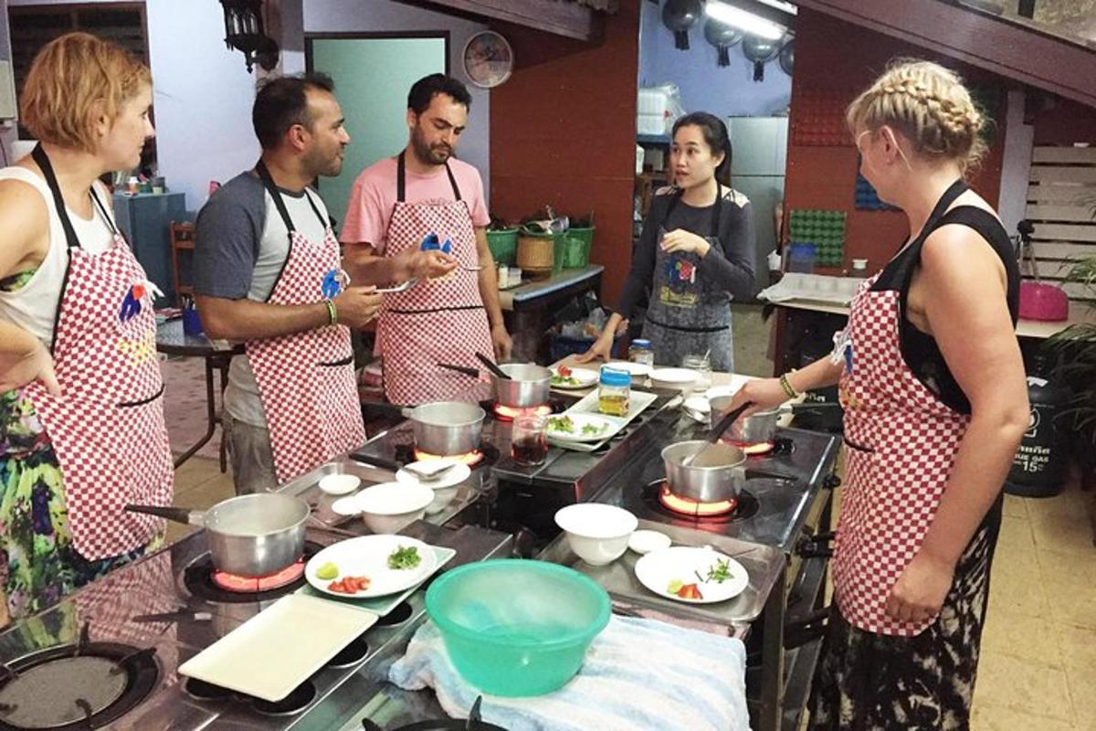 un grup de persones a la cuina preparant menjar