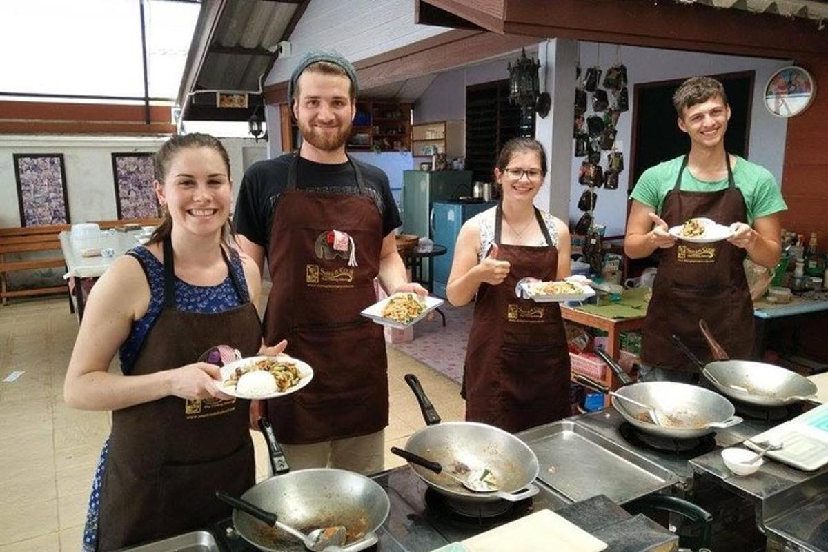 un grup de persones a la cuina sostenint plats de menjar