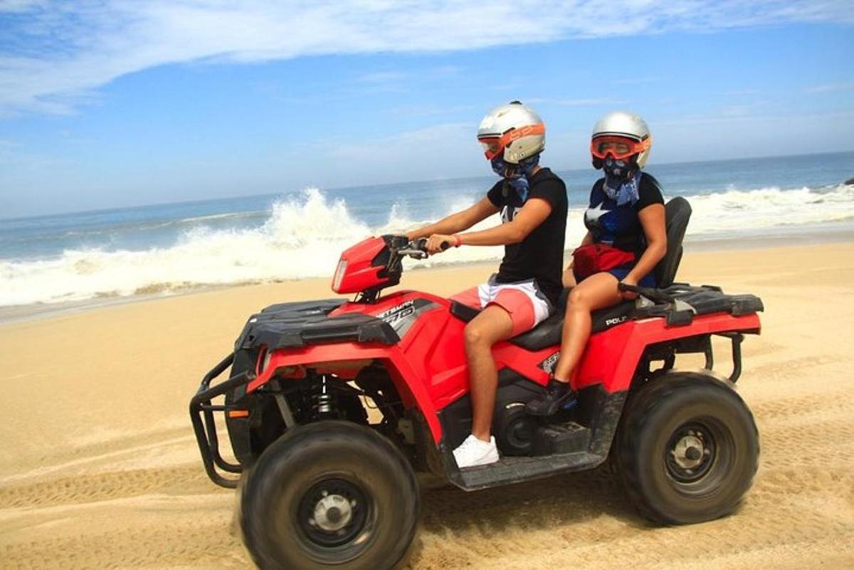 Δύο άτομα κάνουν ποδήλατο quad στην παραλία