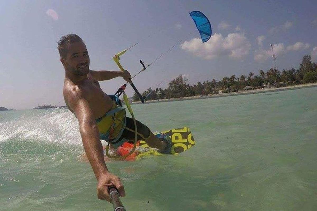 un uomo in acqua che tiene un aquilone