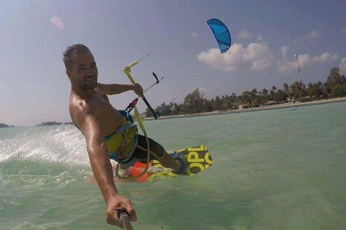 un uomo in acqua con un aquilone nell'oceano