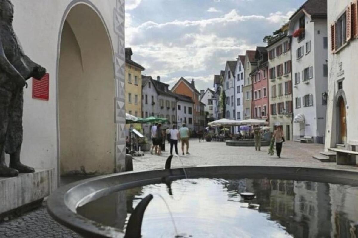 a street with a water fountain in the middle of a city