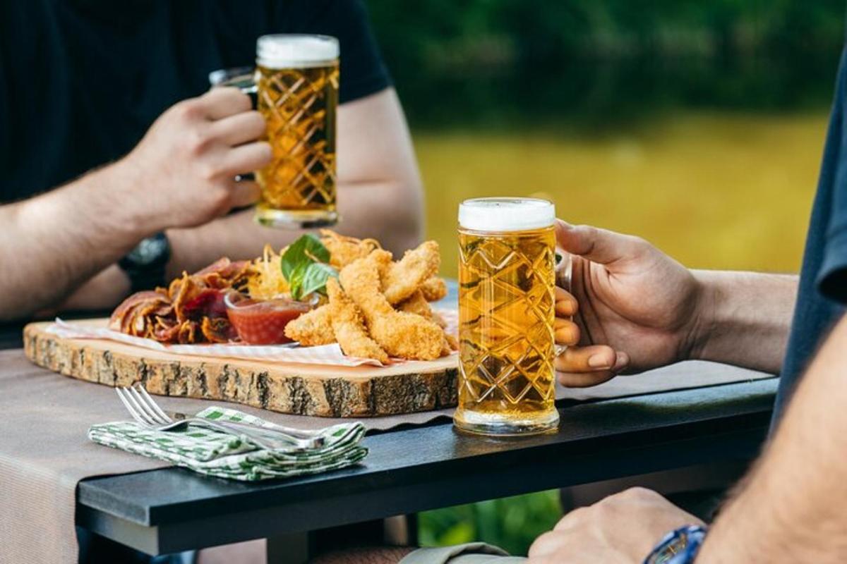 hai người ngồi ở một cái bàn với hai ly bia