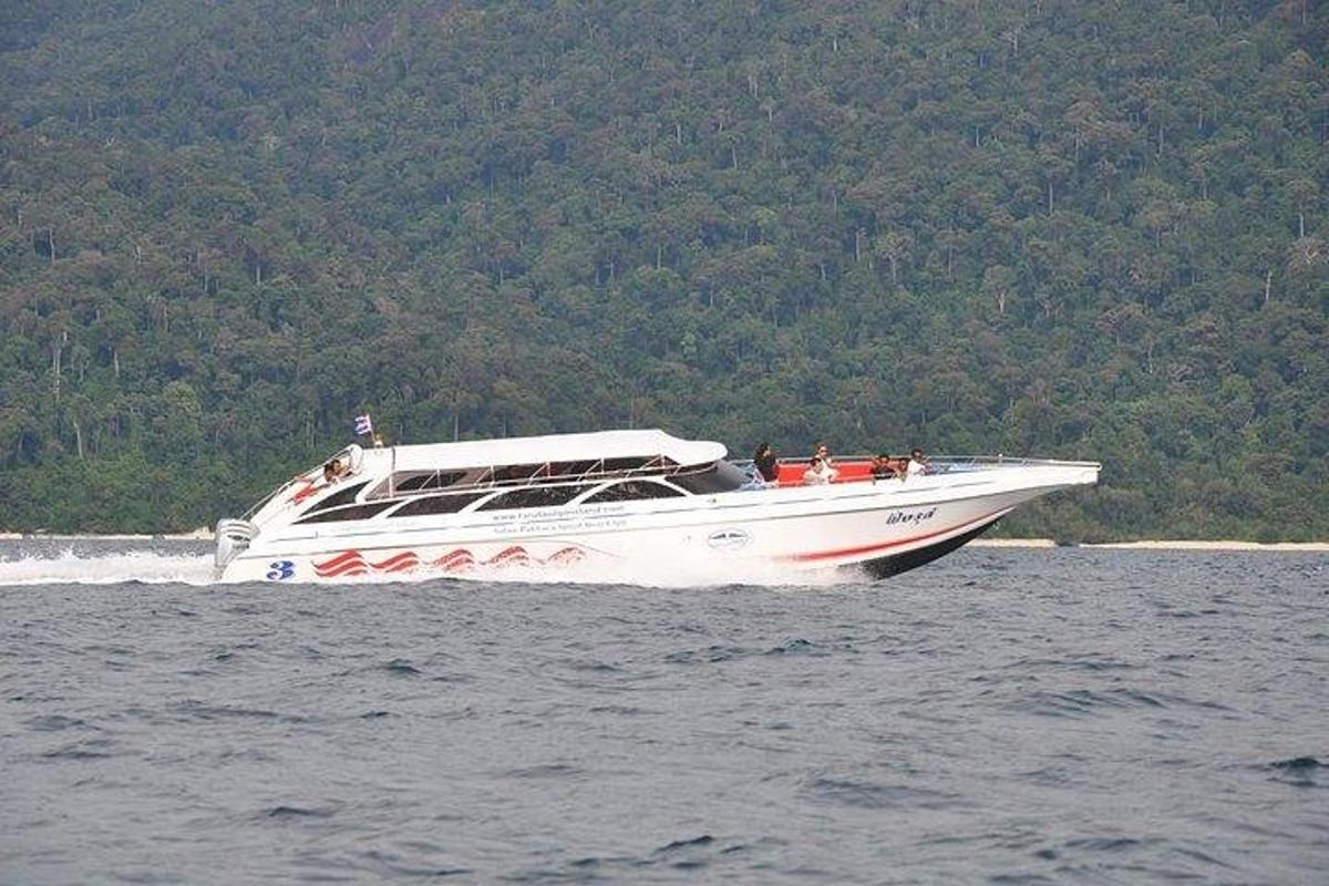 a white boat with people on it in the water