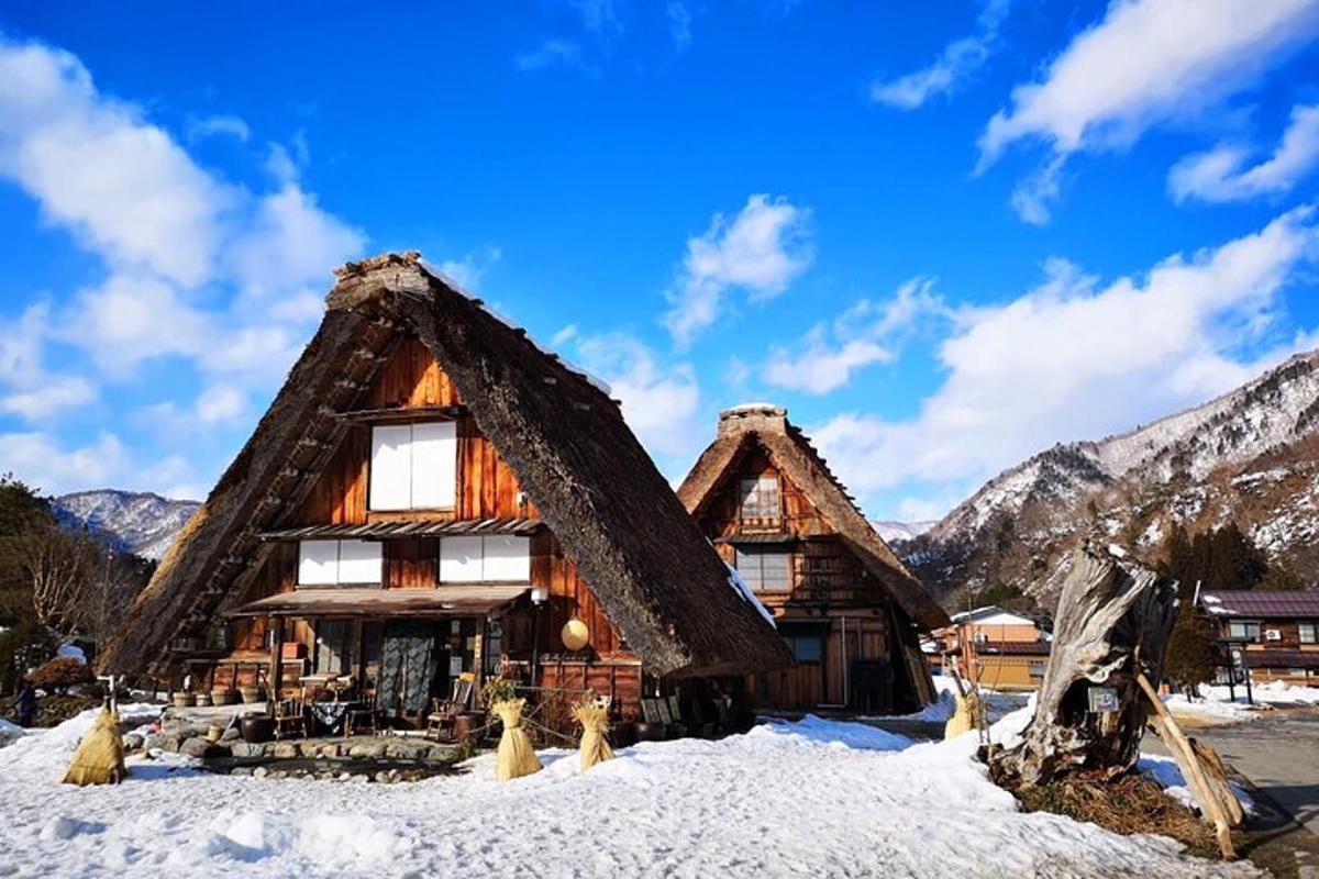 a log cabin in the snow with mountains in the background