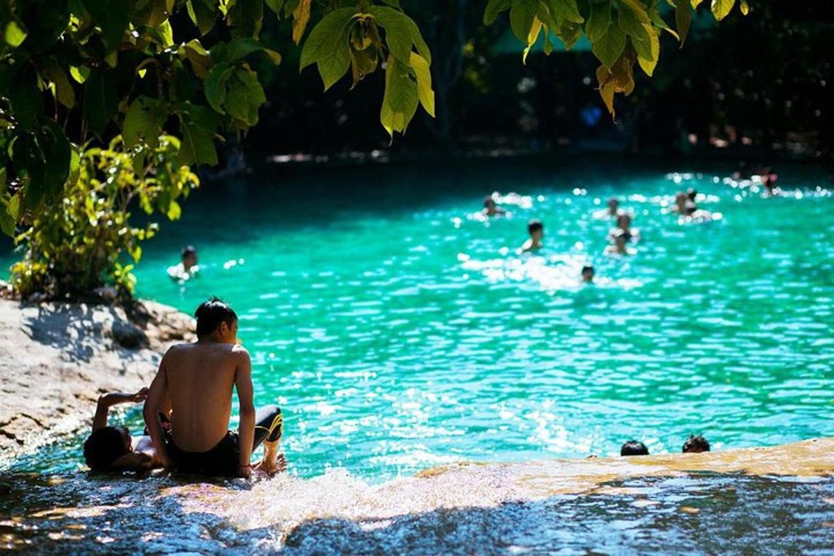 a man sitting on the edge of a body of water