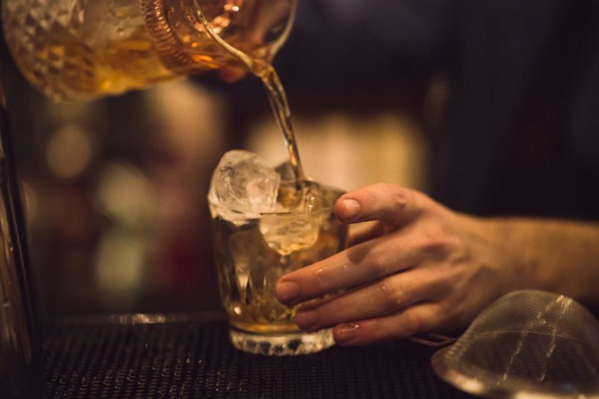 a person pours a drink into a glass