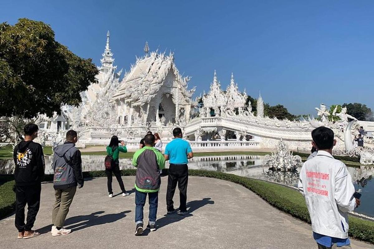 um grupo de pessoas em pé em frente a um templo branco