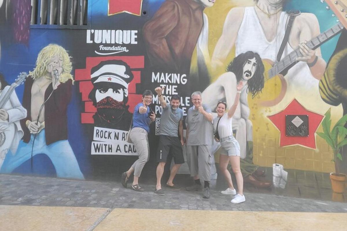 a group of people standing in front of a mural