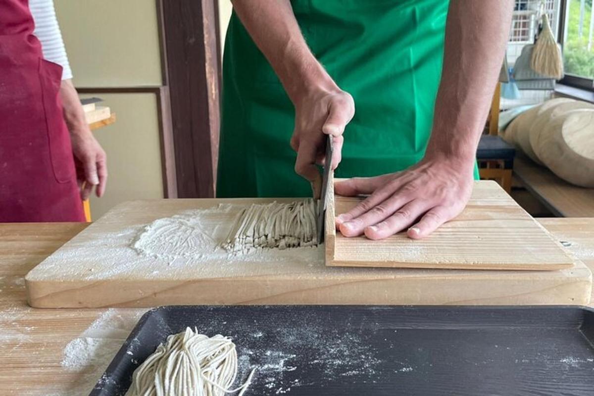 a person cutting a piece of dough on a cutting board