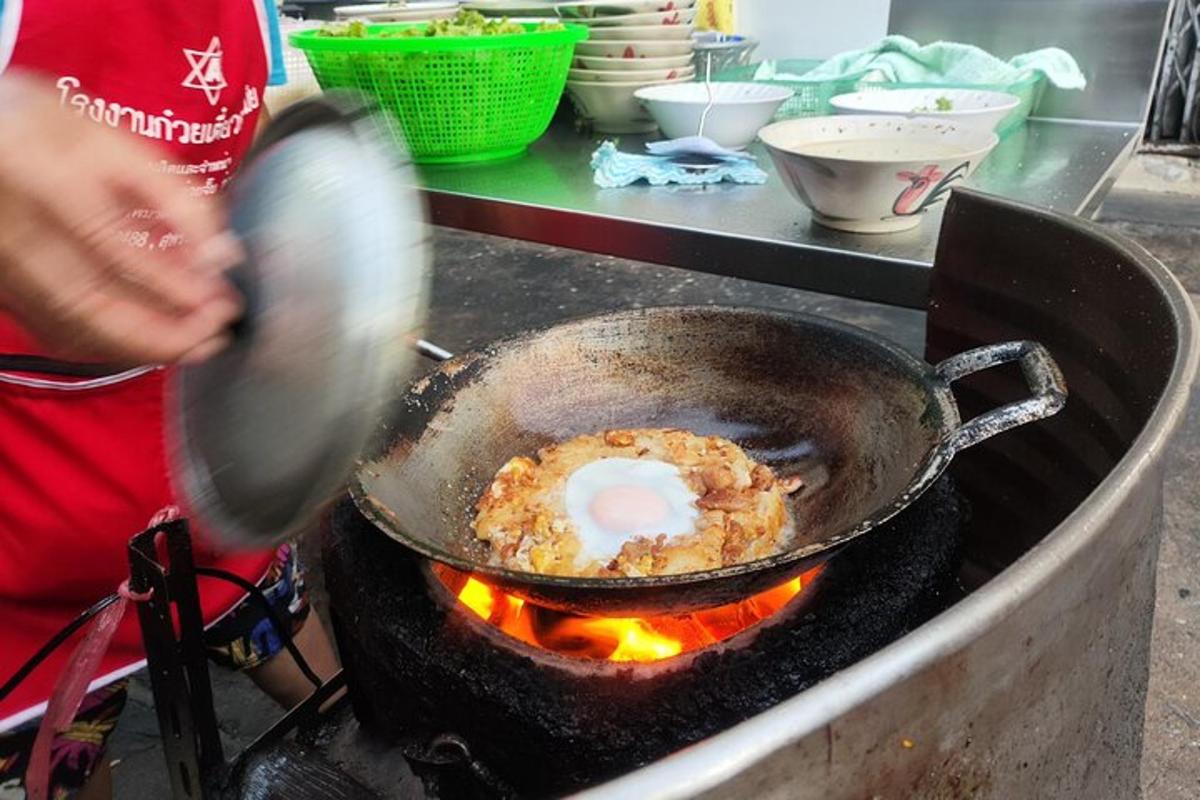 osoba vařící jídlo na pánvi na grilu