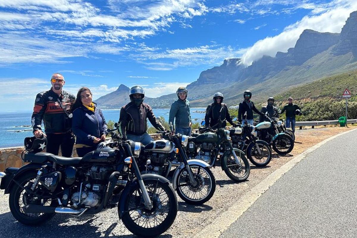 un grup de oameni care stau lângă motociclete pe un drum