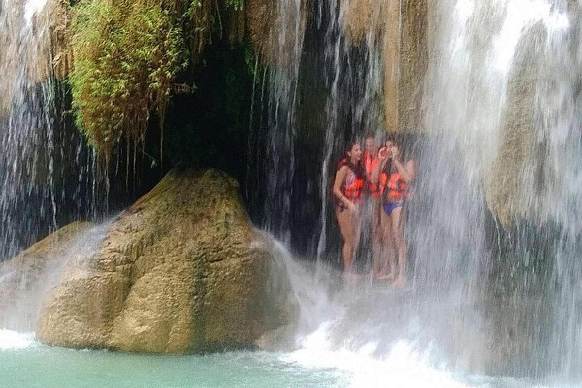 tre persone in piedi sul fondo di una cascata