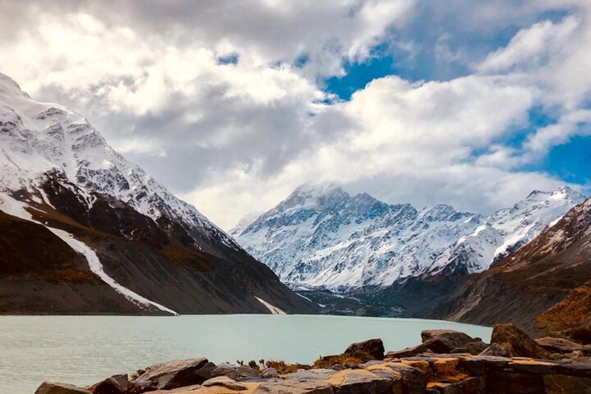 a body of water with snow covered mountains