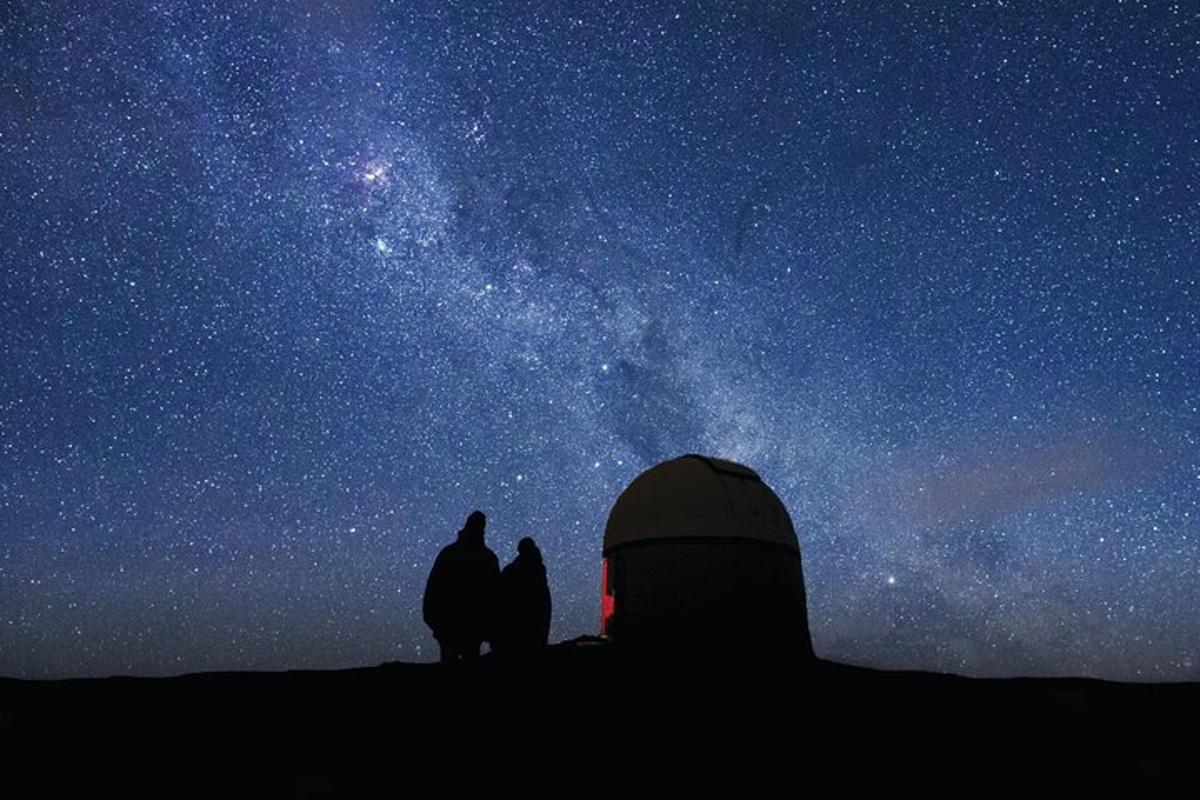 a group of three people looking up at the stars