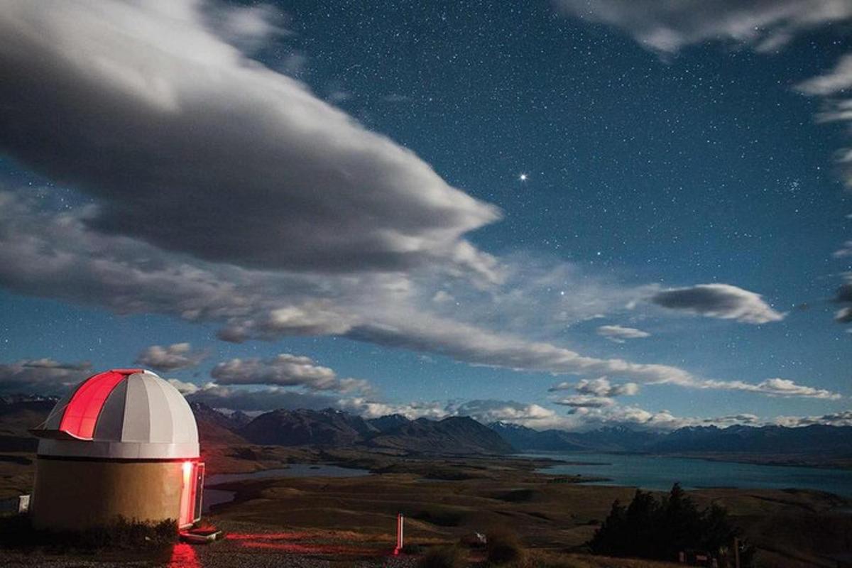 a red and white observatory under a starry sky