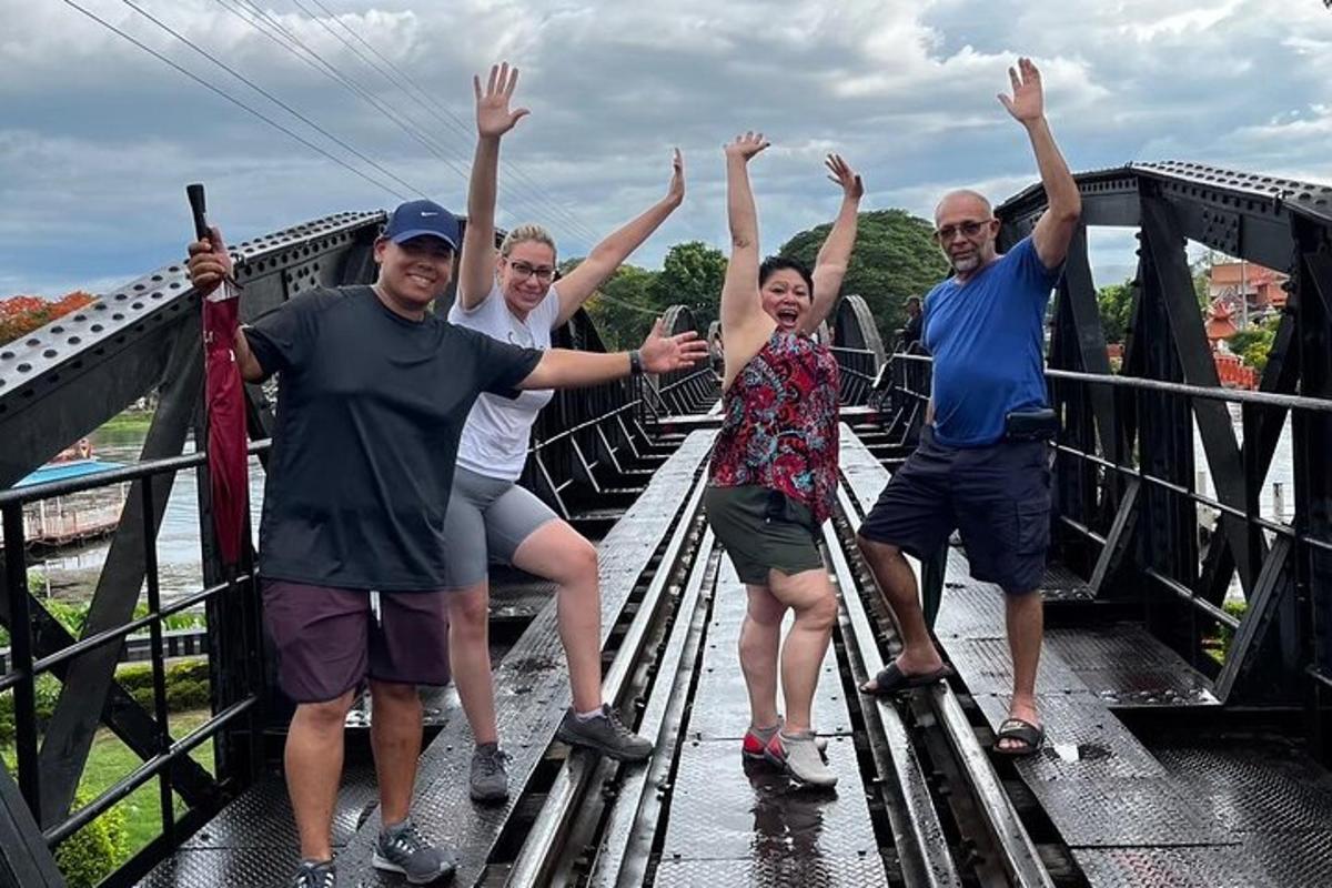 un gruppo di persone in piedi su un ponte con le mani alzate