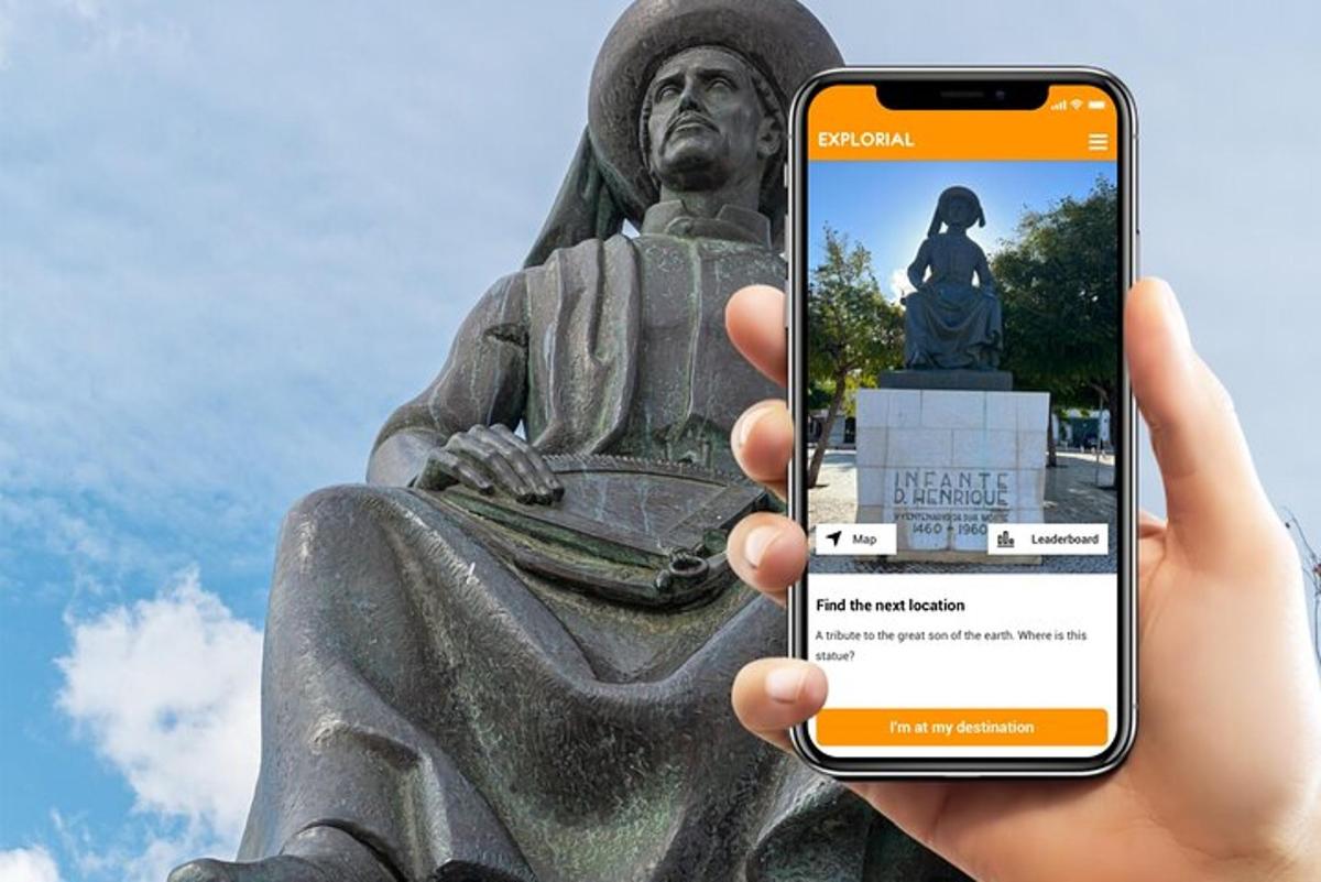 osoba držící mobilní telefon před sochou
