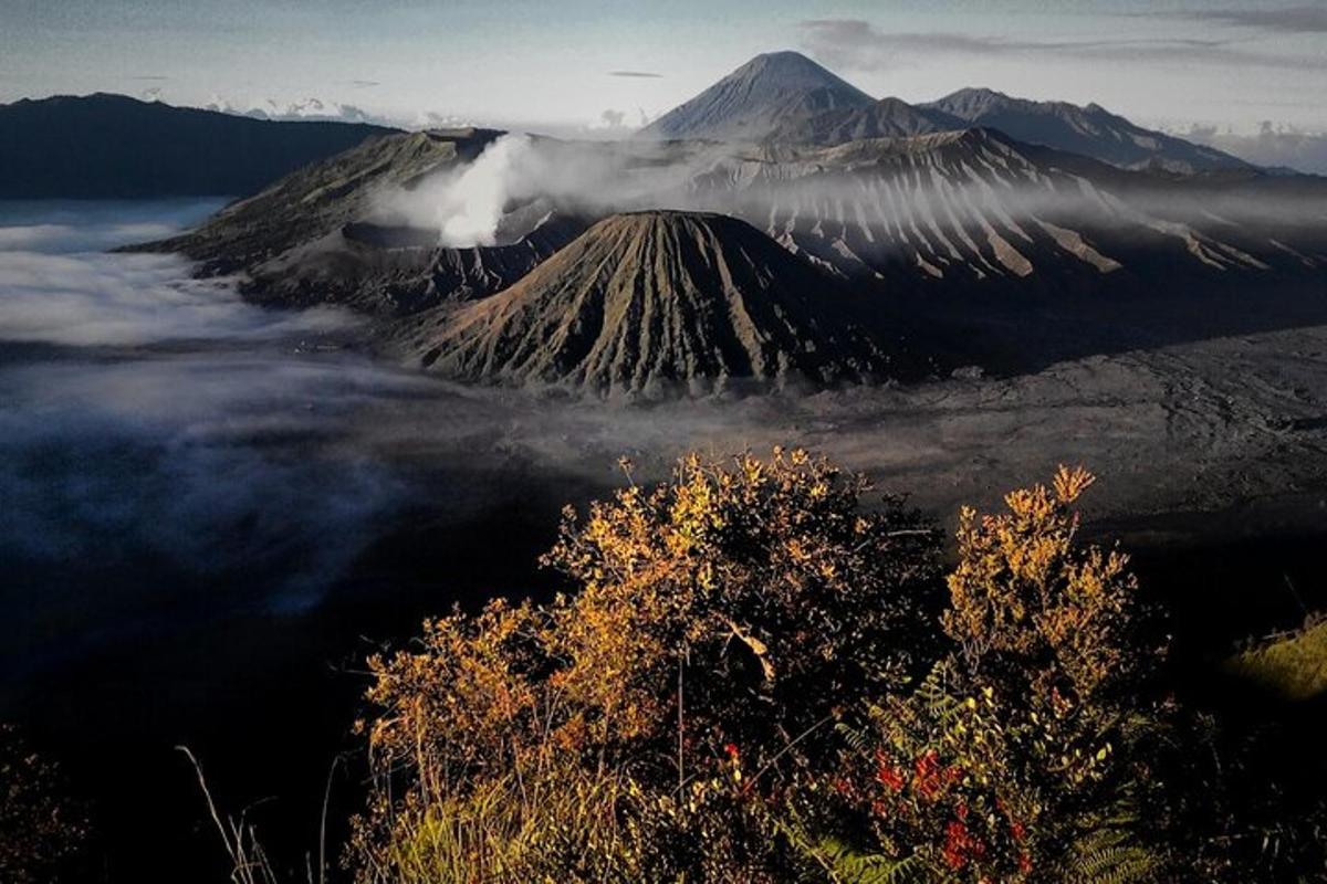 a mountain shrouded in clouds in front of a mountain