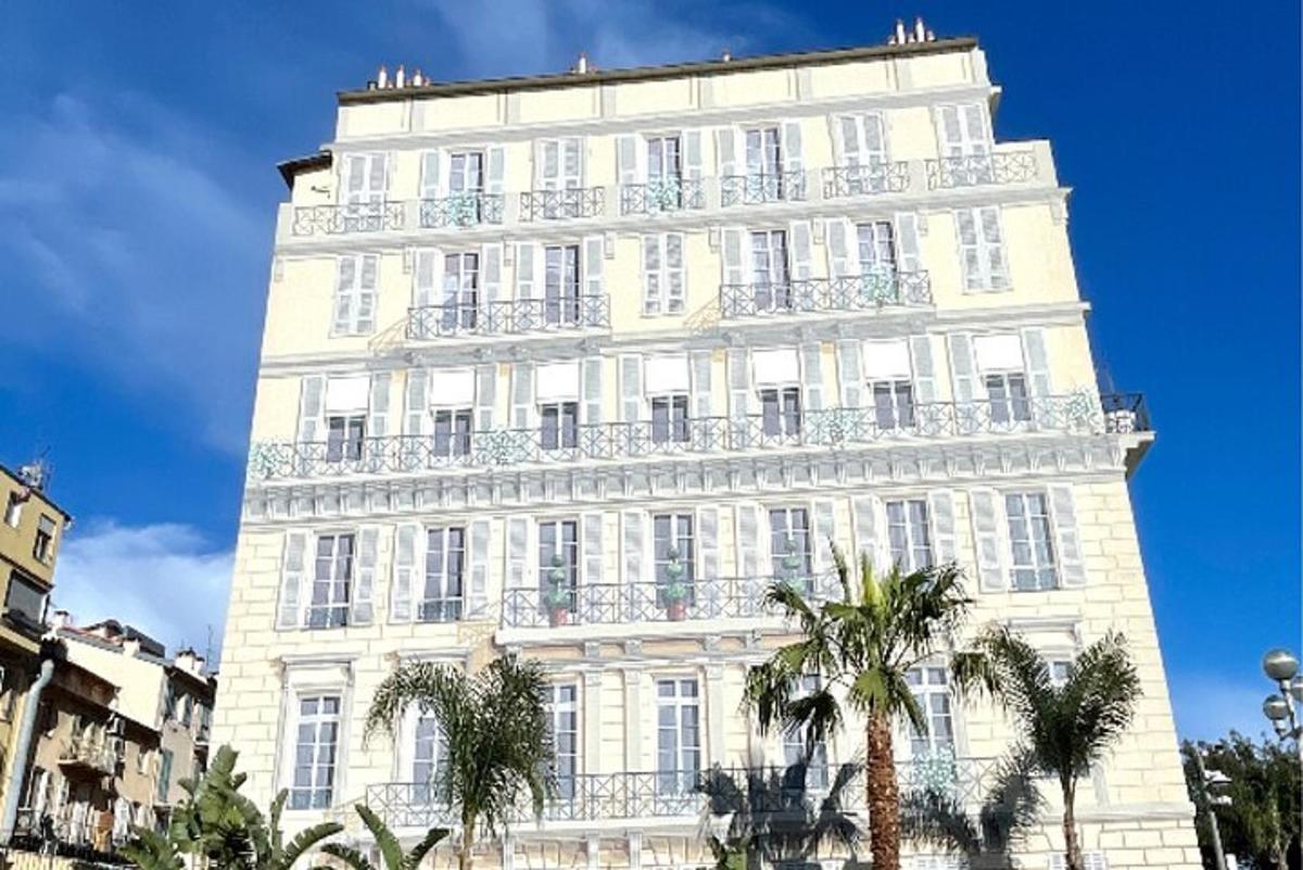 a tall white building with palm trees in front of it