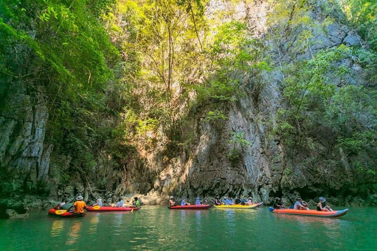 Un grupo de personas haciendo kayak en un río cerca de una cueva.