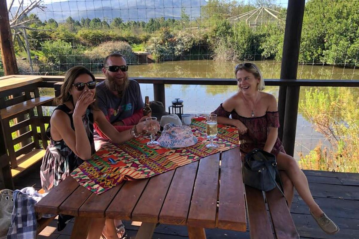 a group of people sitting at a picnic table with a cake