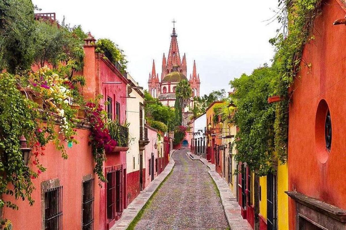 a narrow street with colorful buildings and a cathedral