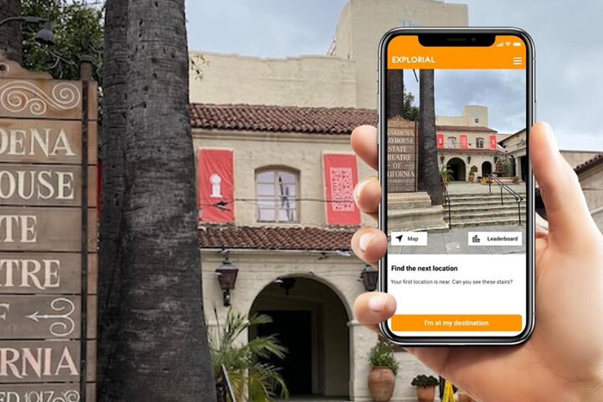 a person holding up a cell phone in front of a building