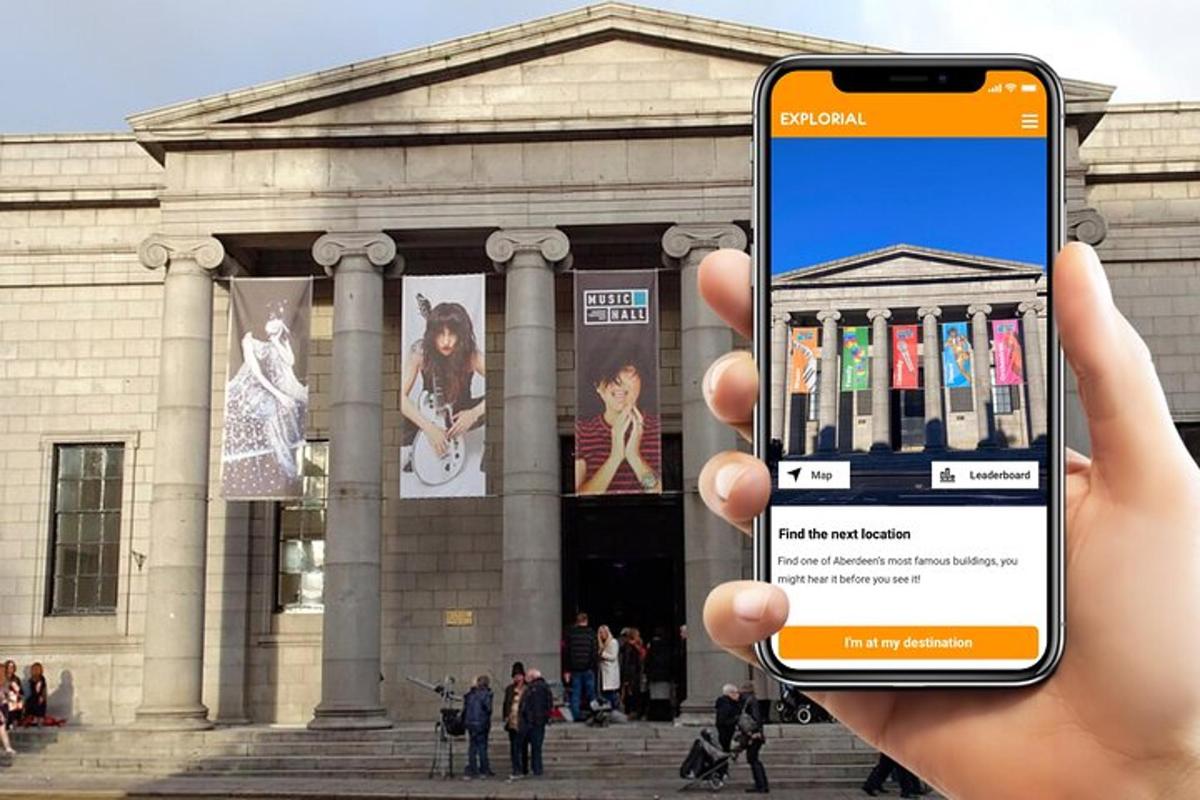 seseorang memegang telefon bimbit di hadapan sebuah bangunan