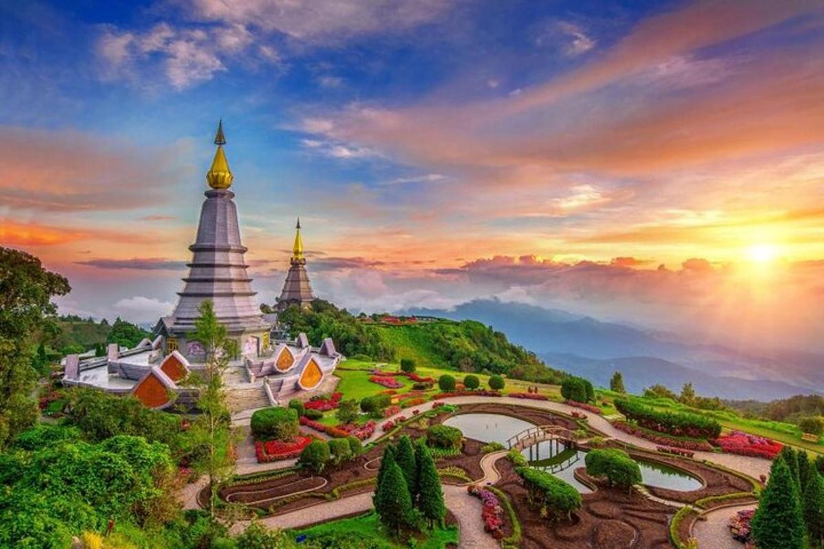 a temple in the mountains with a sunset in the background