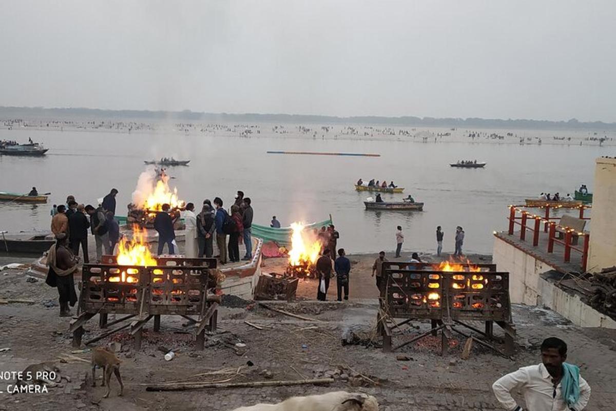 a group of people standing around fires on a body of water