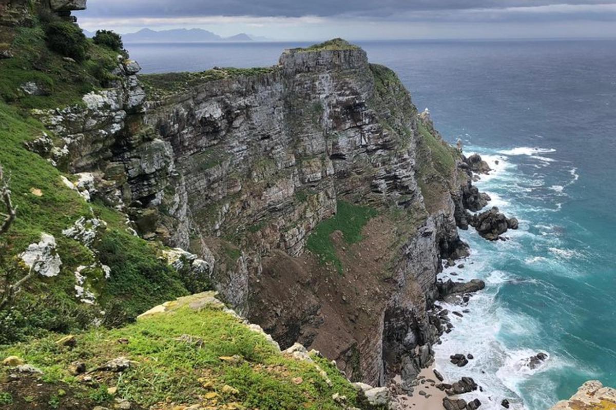 una montagna rocciosa con l'oceano e una spiaggia
