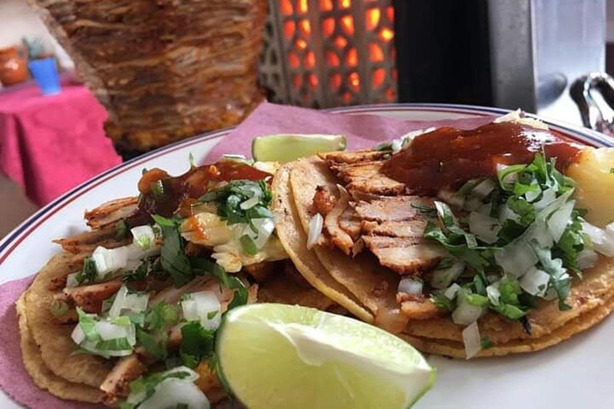 en tallerken med mat med tacoer og en lime