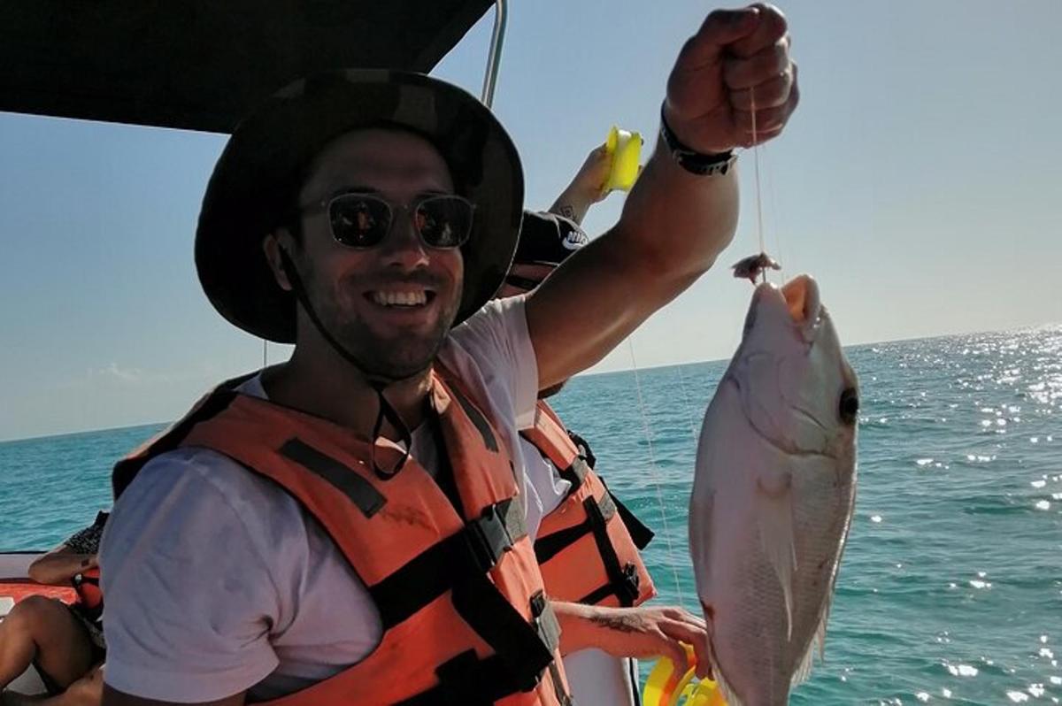 a man holding a fish on a boat