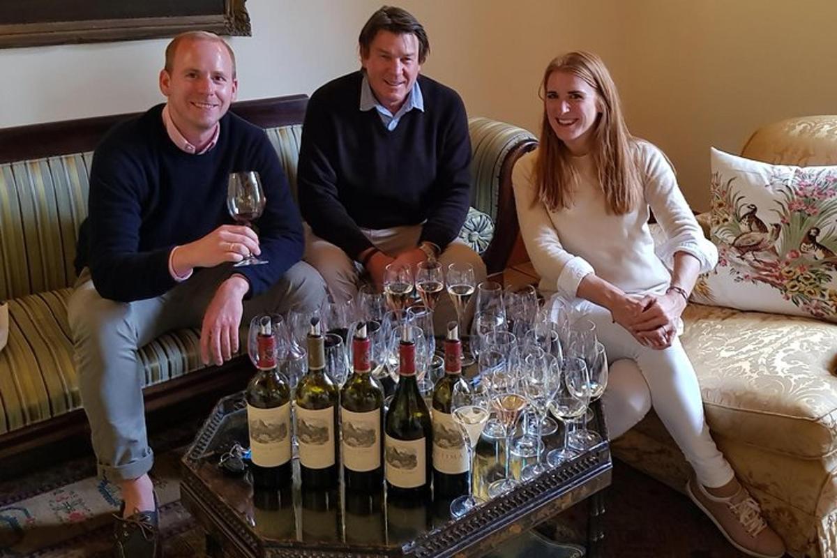 a group of three people sitting on a couch with wine glasses